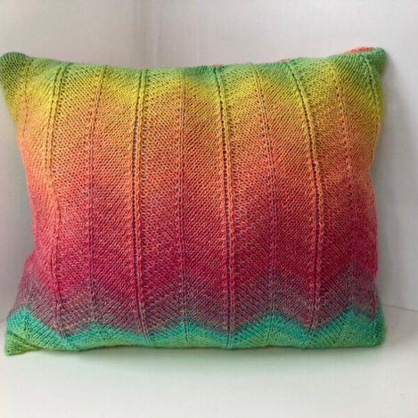 Handgestricktes Kissen aus Wolle in Regenbogenfarben